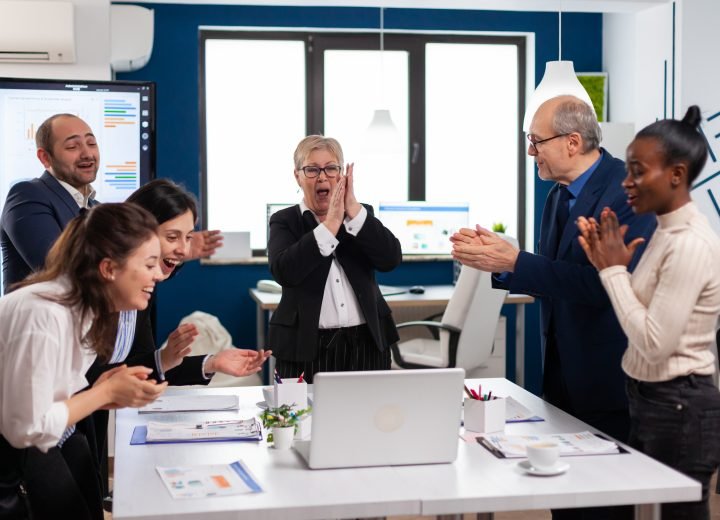 Diverse executive business team clapping in conference room | Faber Infinite