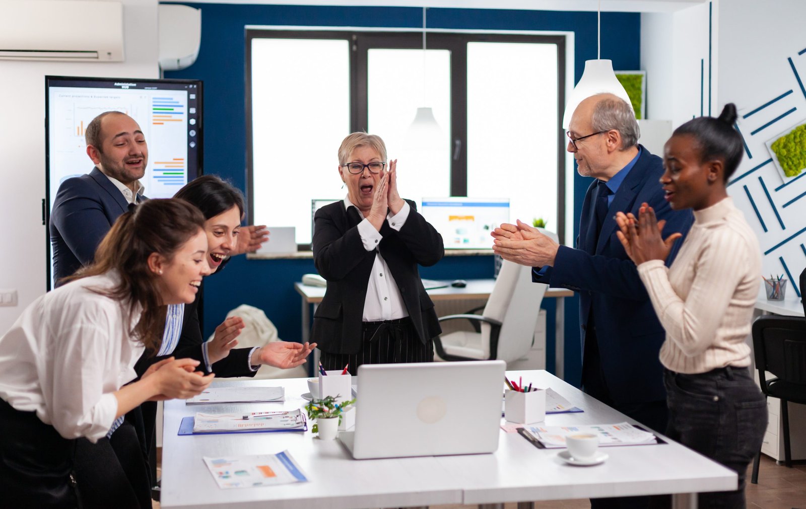 Diverse executive business team clapping in conference room | Faber Infinite