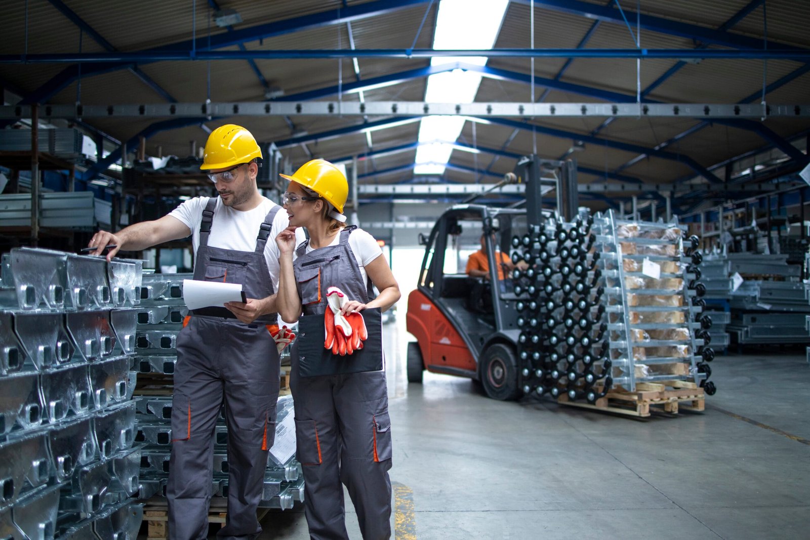 Factory workers checking quality of products in industrial warehouse.