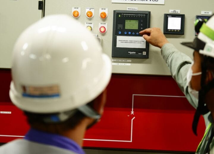 Engineers operating a control panel in a facility