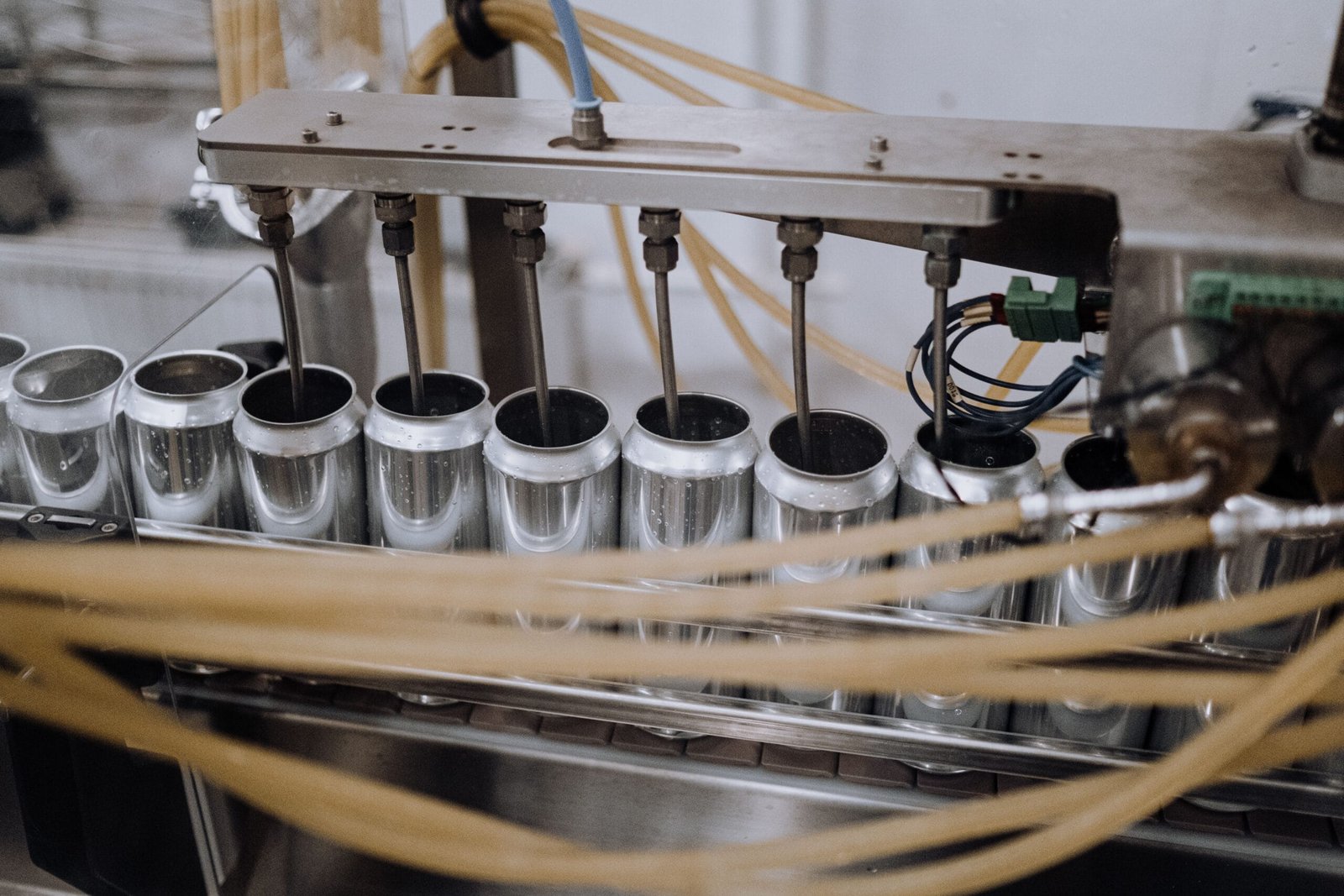 Close-up of automated machinery on a beverage can filling the production line inside a manufacturing plant