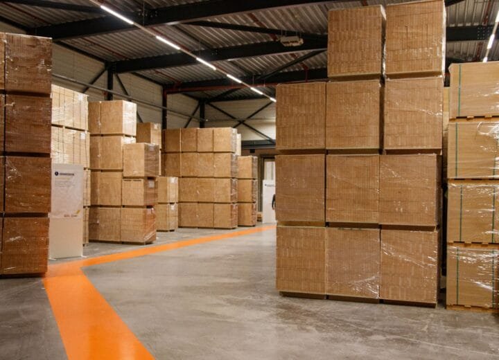 A spacious industrial warehouse filled with stacked cardboard boxes for storage and shipping.