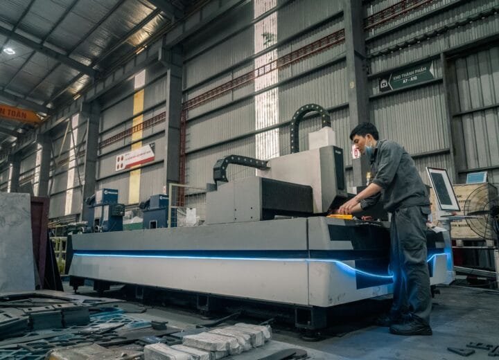 A worker with a mask operating machinery in a spacious industrial warehouse