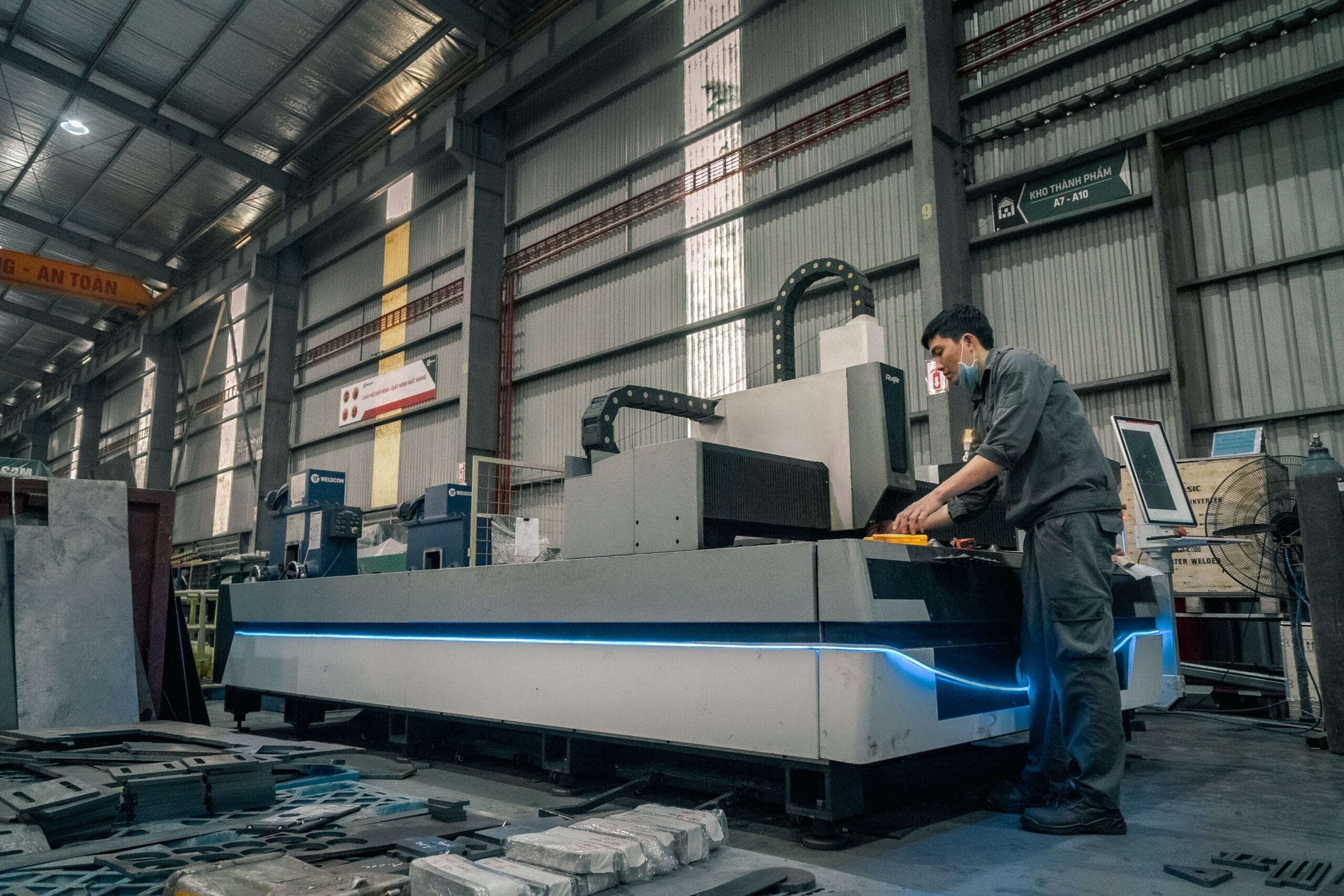 A worker with a mask operating machinery in a spacious industrial warehouse