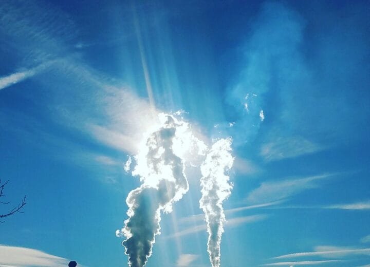 Silhouette of an industrial plant with steam emissions