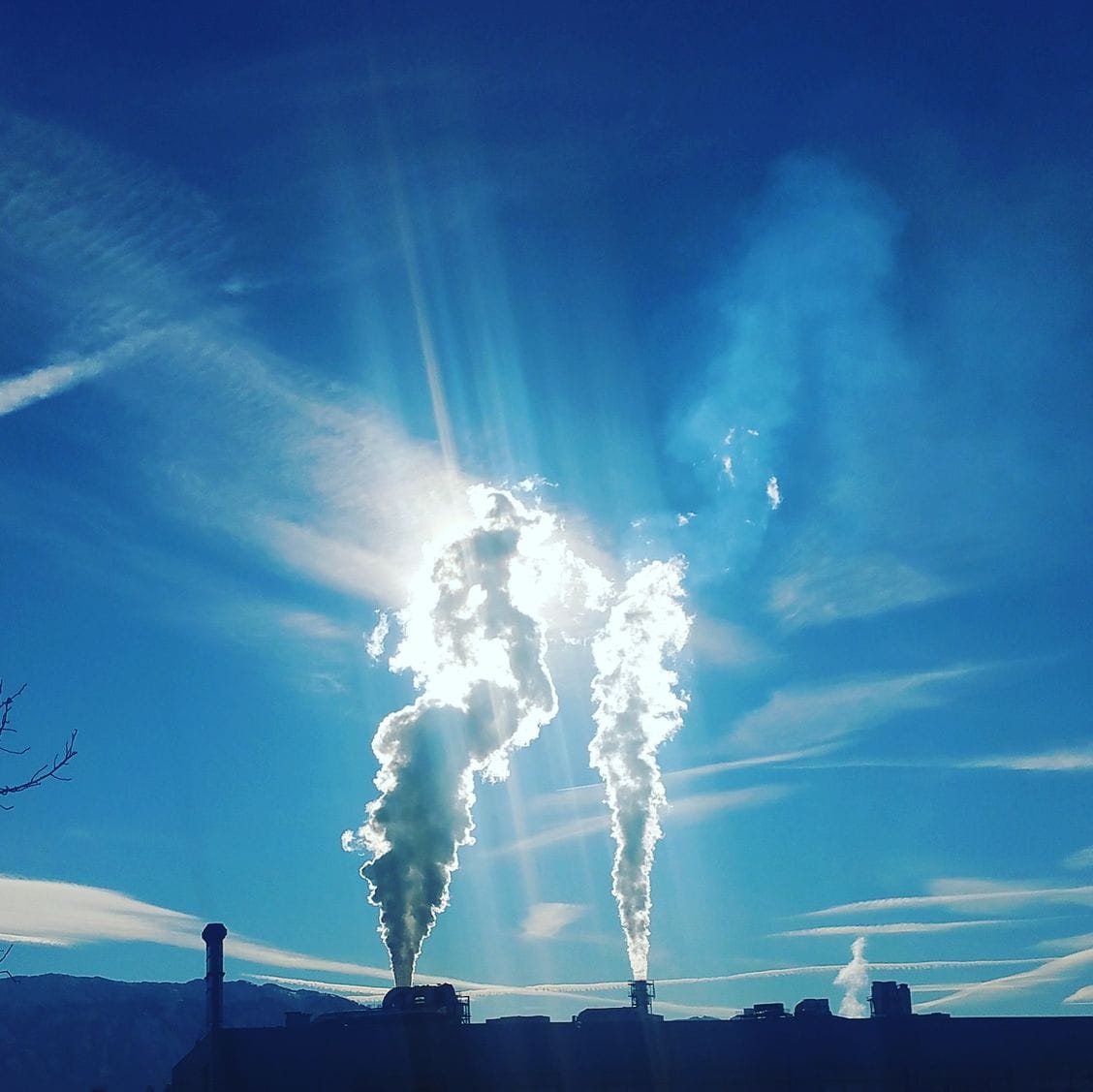 Silhouette of an industrial plant with steam emissions