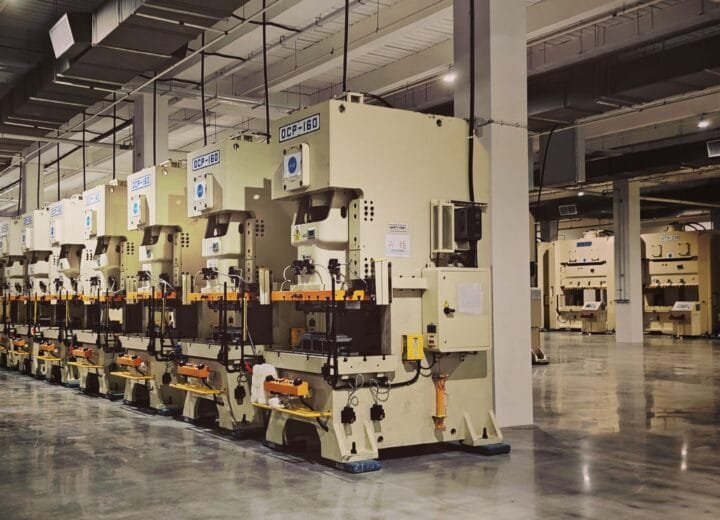 A row of industrial machines and manufacturing equipment on a factory floor