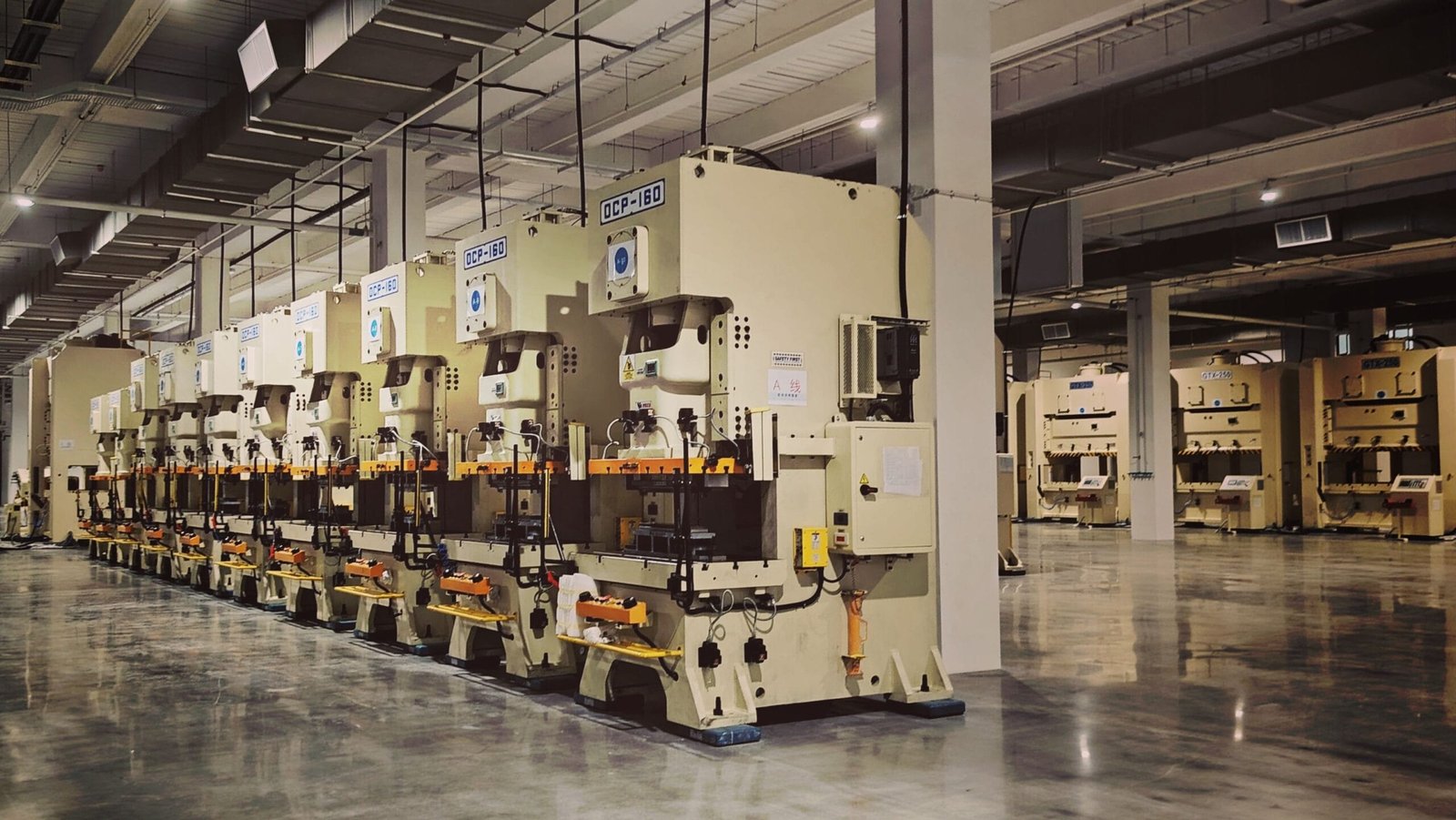 A row of industrial machines and manufacturing equipment on a factory floor
