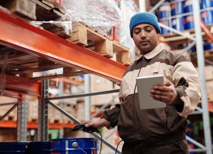A warehouse employee scans items using a tablet, ensuring inventory accuracy.