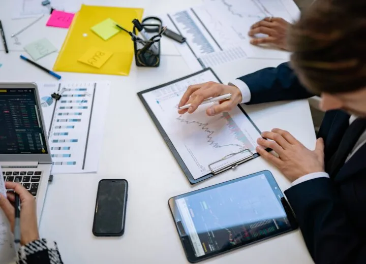Team reviewing financial charts and digital data on tablets in an office setting