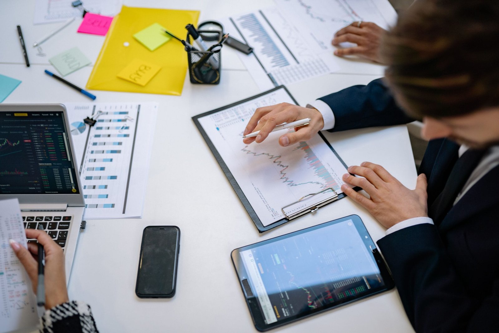 Team reviewing financial charts and digital data on tablets in an office setting