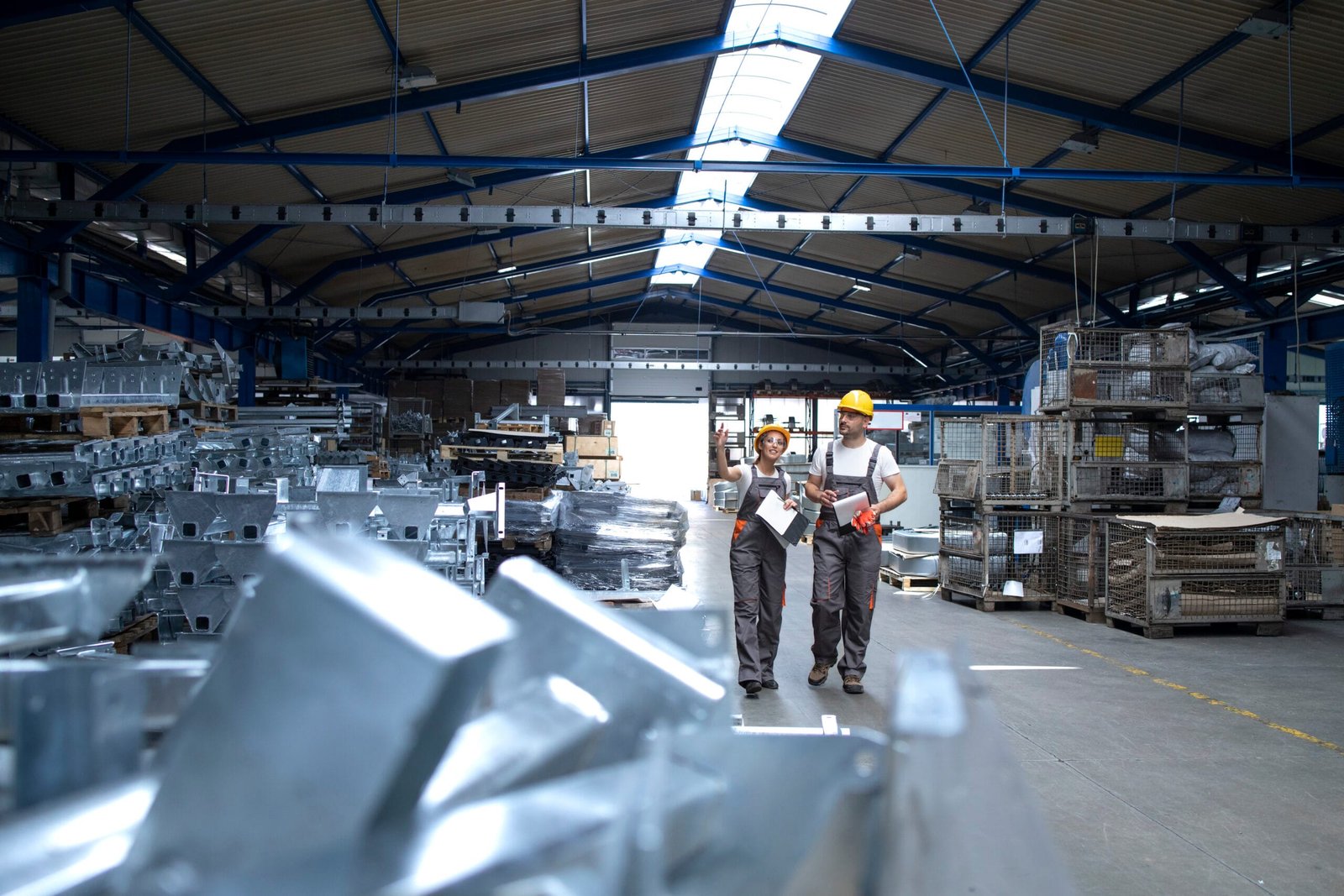 Factory workers in industrial production hall.