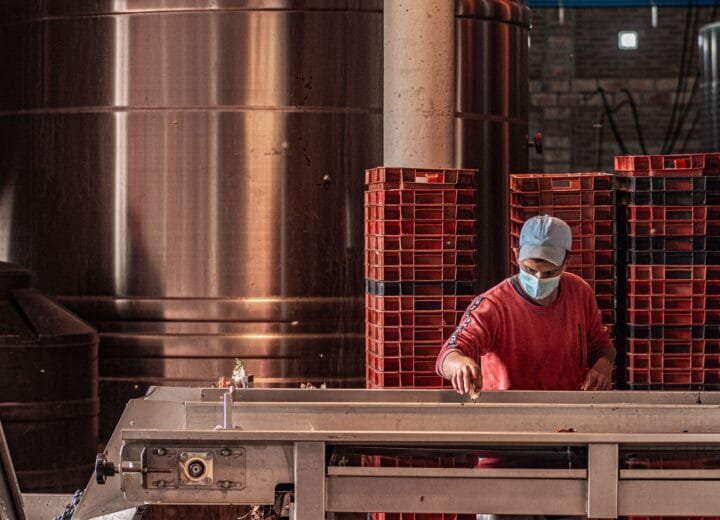 Industrial worker wearing a face mask, operating machinery in a factory