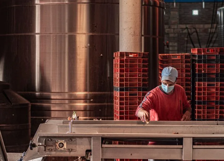 Industrial worker wearing a face mask, operating machinery in a factory