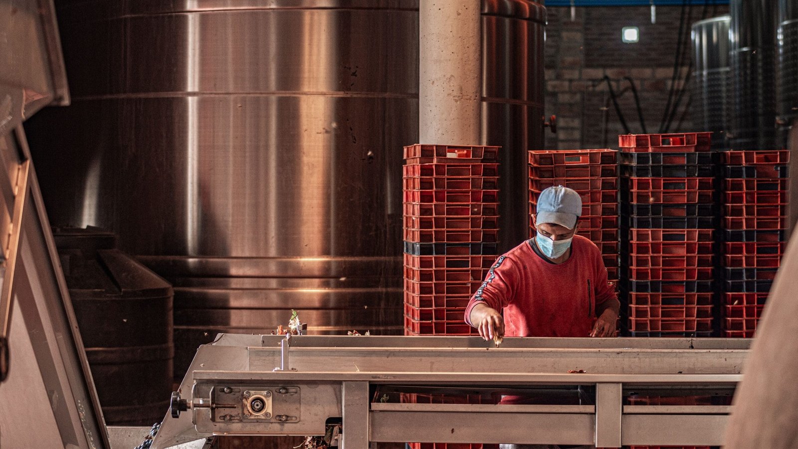 Industrial worker wearing a face mask, operating machinery in a factory