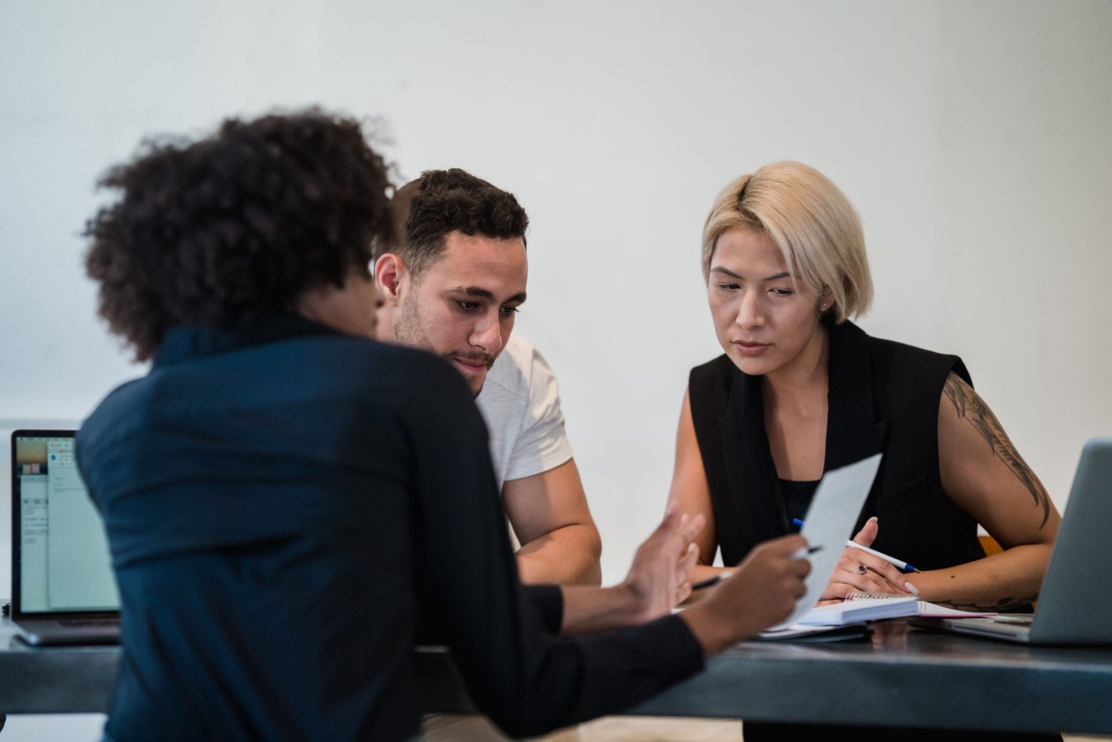 Diverse team engaged in a focused meeting at a contemporary workplace, discussing project details