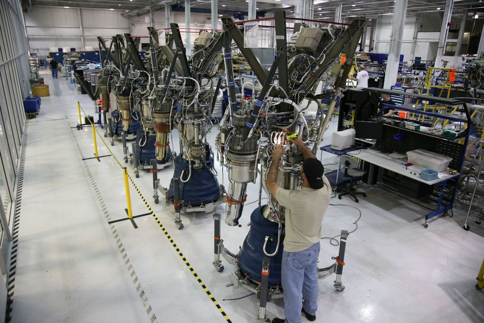 A technician inspects rocket engine machinery inside a modern industrial factory