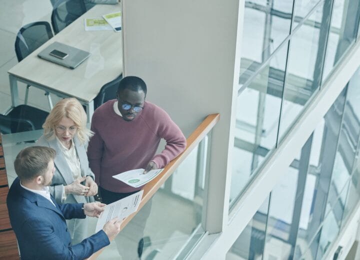 High angle view of diverse colleagues collaborating in a modern office setting.